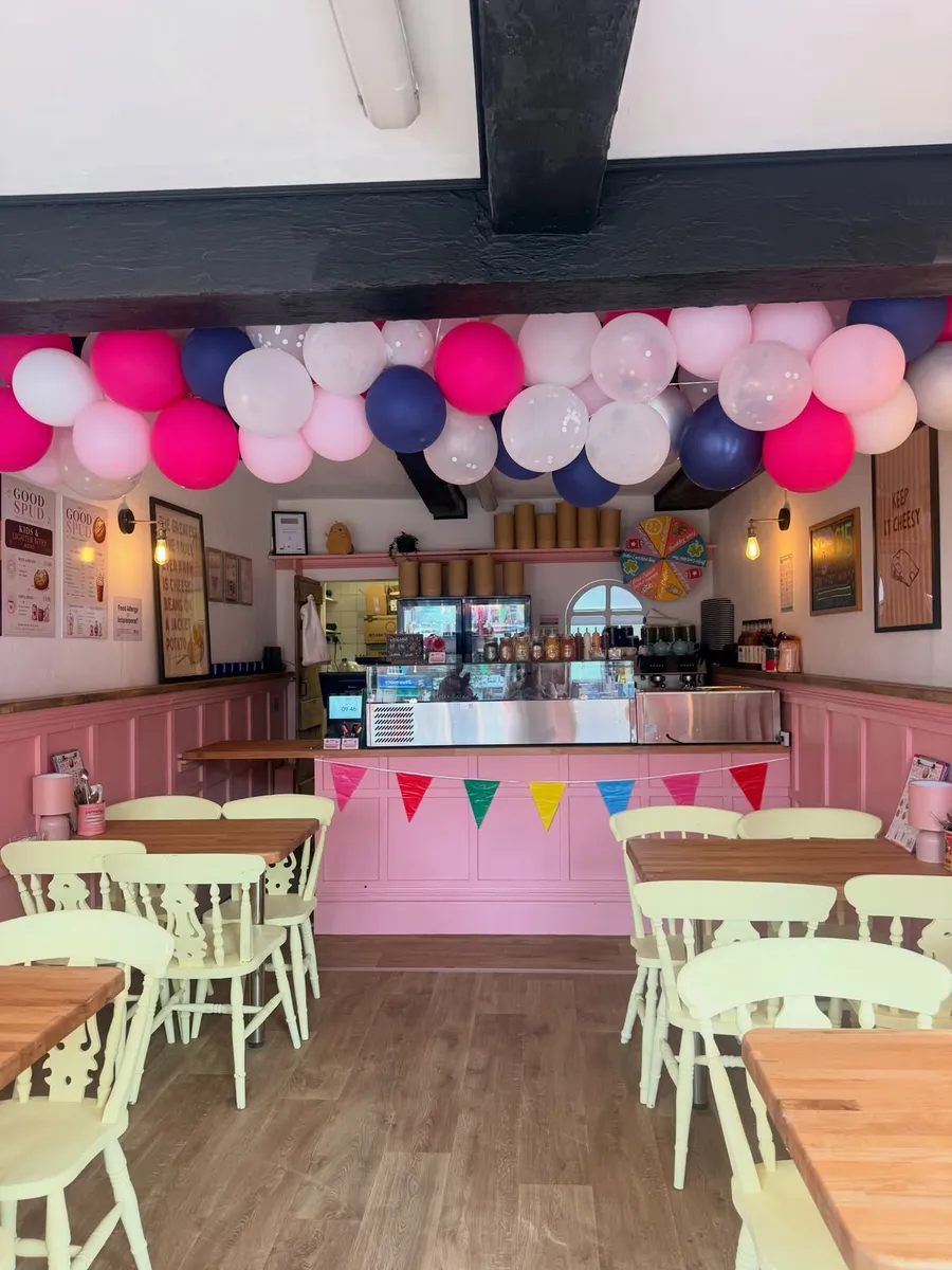 The Good Spud Horncastle interior with pink walls, vintage chairs and balloon decorations on opening day